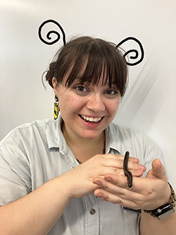 Kyleigh holds a small snake while wearing an inset antenna head piece