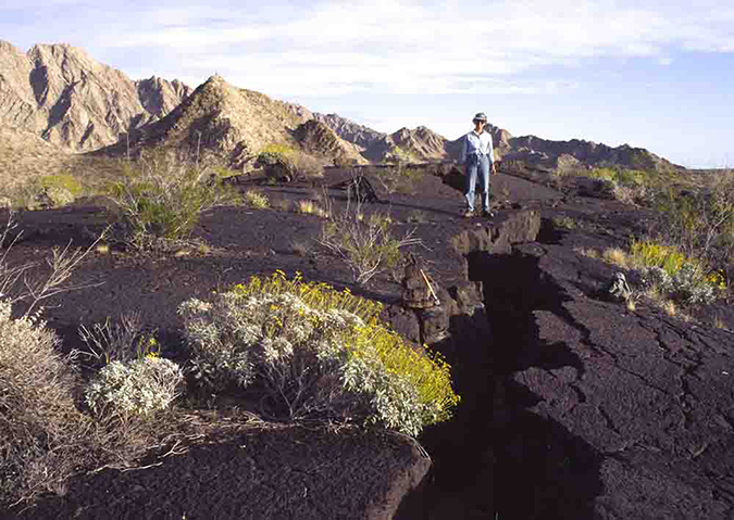 Woman standing by lava flow