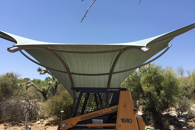 Exhibit construction continues under the newly erected shade structure