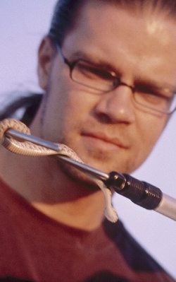 Dr Sean Bush holds a snake at arm's length