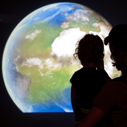 Father and daughter watching the NASA climate change exhibit